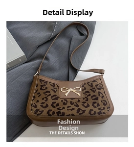 Détail d'un sac léopard avec boucle nœud doré et bordures en similicuir marron poli