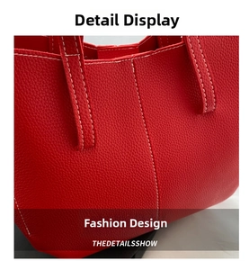Close-up of red lychee grain leather tote with precision white contrast stitching detail