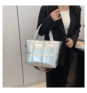 Sac fourre-tout argenté matelassé avec une large bandoulière tissée colorée sur mannequin
