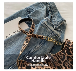 Detailed close-up of leopard print handbag with golden metal chain rings and handle