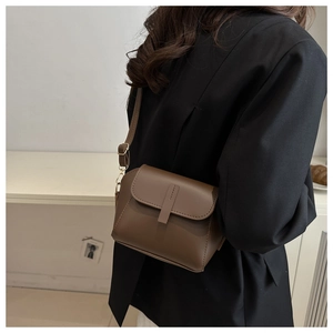 Side view of dark brown faux leather crossbody bag with adjustable strap and gold hardware