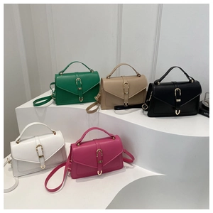 Mini crossbody bags in five colors displayed on white geometric stands with metal buckles