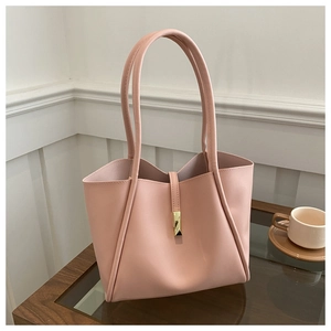 Detail of pink leather tote bag with elegant gold metal buckle and sleek shoulder strap