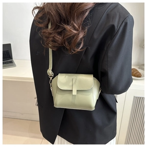 Sage green minimalist crossbody bag shown in a real-life setting for scale and style