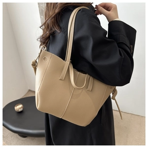 Close-up of beige lychee grain PU leather tote bag with stylish side knot detail