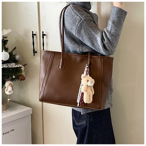 Deep brown pebble leather tote bag with stylish scarf and bear charm detail