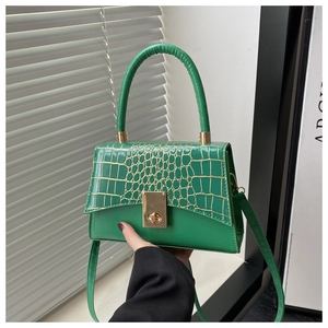 Detailansicht der grünen Handtasche mit Krokodilprägung und elegantem goldenem Metallschloss