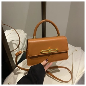 Detailed view of brown leather square crossbody bag with gold chain buckle and top handle