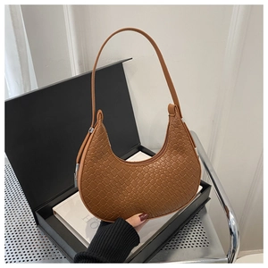 Detail showing brown faux crocodile leather texture and crescent shape of the shoulder bag