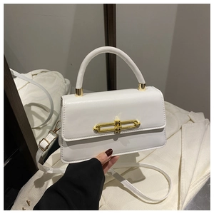 Detailed view of the gold-tone metal lock and clasp on a white structured leather handbag