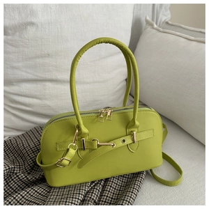Nahaufnahme der grasgrünen Retro-Kissentasche mit goldenen Details auf dem Sofa