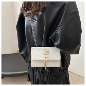 Detail of matte cream crossbody bag with gold double S logo and tassel fringe