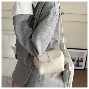 Lifestyle view of minimalist cream-colored crossbody bag shown on model for size and fit