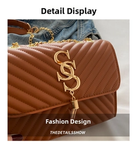 Detail of brown quilted faux leather crossbody bag with gold metal logo and chain strap