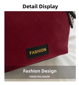 Detail of burgundy suede tote with black fashion label and geometric scarf accent
