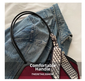 Close-up of burgundy suede tote bag with geometric silk scarf wrapped on black handle