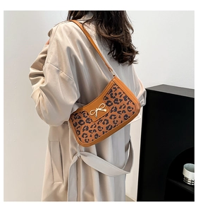 Détail du sac sous le bras à motif léopard avec boucle nœud doré en similicuir lisse