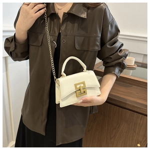 Detailed close-up of a white leather crossbody bag with elegant gold lock and chain