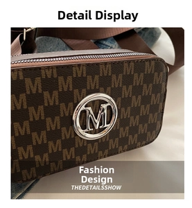 Close-up of brown crossbody camera bag with monogram M pattern and metallic logo