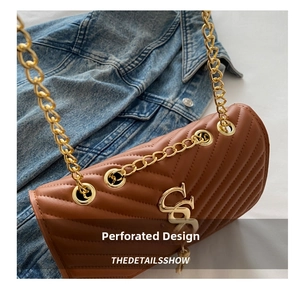 Close-up of caramel brown quilted shoulder bag with V-pattern and gold chain strap