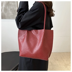 Detailed view of dark red woven texture on a large capacity tote bag worn by a model