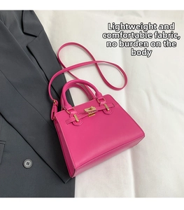Close-up of fuchsia contrast tote with golden twist lock and smooth leather texture