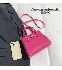 Rose pink handbag size comparison with phone showing trapezoidal design and gold hardware