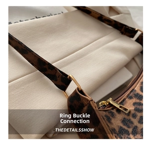 Detail of golden ring link and leopard print leather texture on a fashion underarm bag