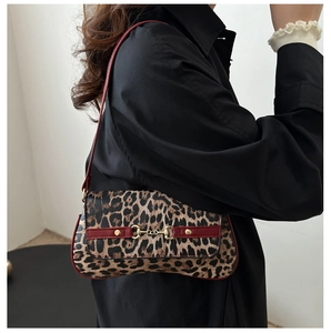 Détail du sac léopard avec boucle mors dorée et finitions en cuir bordeaux élégant