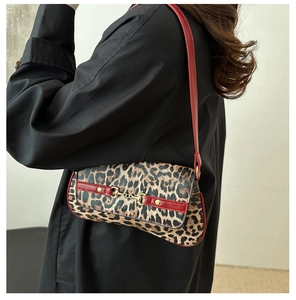 Close-up of leopard print underarm bag with red leather trim and golden horsebit detail