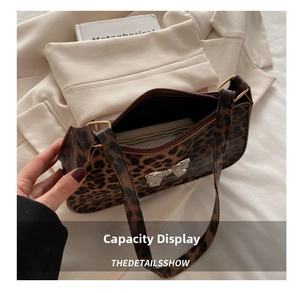 Close-up of leopard print baguette bag showing spacious interior and silver bow detail
