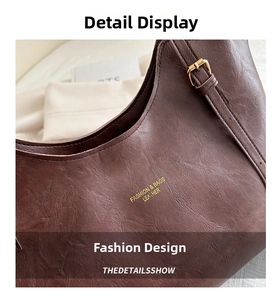 Detail of vintage brown leather tote bag with gold lettering and adjustable metal buckle