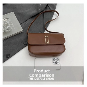 Detaillierte Draufsicht einer braunen Ledertasche mit goldener Schnalle auf grauem Blazer