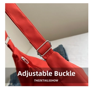 Dettaglio della fibbia in metallo argento e della tracolla in nylon rosso della borsa