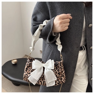 Dettaglio borsa leopardata con fiocco in organza bianca e manico arricciato da donna