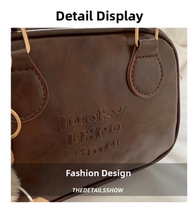 Detail of brown leather handbag with lucky LHCO Smu embossing and gold metal rings