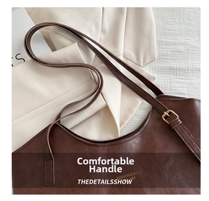 Close-up of a dark brown faux leather shoulder bag with a gold metal buckle detail