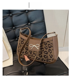 Détail du sac à bandoulière léopard avec boucle nœud doré et texture façon crocodile