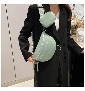 Detail of mint green multi-zipper chest bag with textured leather and herringbone strap