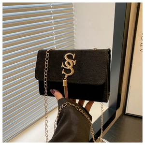Close-up of black matte crossbody bag featuring gold double S logo and tassel chain detail