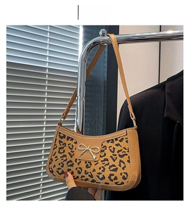 Détail du sac léopard avec fermoir nœud doré en cuir de crocodile synthétique kaki
