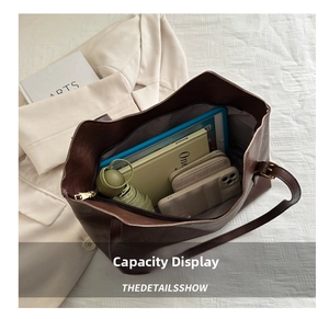 Detail view of large brown tote bag showing spacious capacity for tablets and daily items