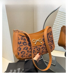 Détail du sac léopard avec nœud doré et cuir PU texturé pour un look élégant et chic