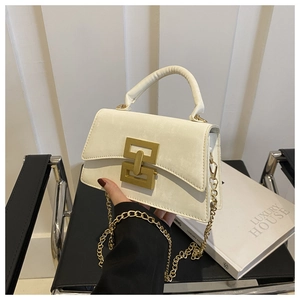 Close-up of elegant off-white crossbody bag with luxury gold lock and chain strap
