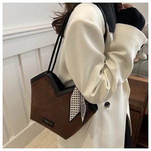 Detail of dark brown tote bag featuring a deep V-cut edge and black contrast trim