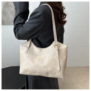 Detail of minimalist tote bag with vintage texture and gold hardware on shoulder strap
