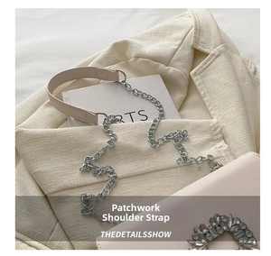 Detail of pink leather handbag with crystal buckle and metal chain strap on beige blazer