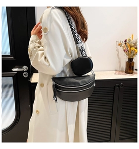 Detail of black crescent moon bag with geometric strap and detachable round pouch