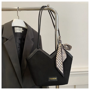 Detail of black tote bag with V-shaped cut, fashion label and geometric silk scarf