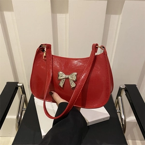 Red glossy patent leather underarm bag with silver bow accent and zipper closure